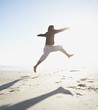 Full view of man jumping in sand at beach