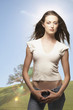 Portrait of woman standing with thumbs hooked in jeans