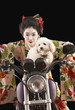 Asian woman in ethnic clothes driving a motorcycle with a dog