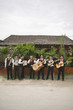 Mariachi band in front of building playing their instruments