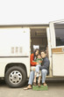 Family sitting in doorway to recreational vehicle