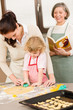 Little girl with mother cutting out cookies