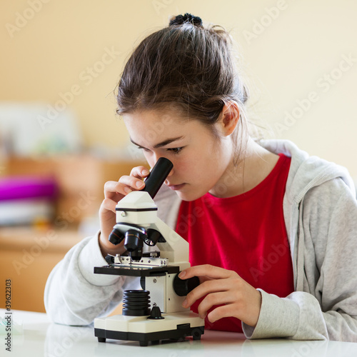 Foto: Girl examining preparation under the microscope Girl examining preparation under the microscope
