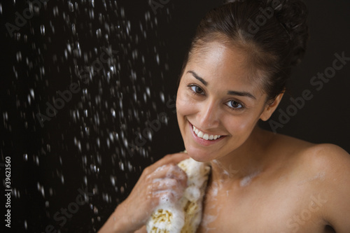 Photo: Close up portrait of woman bathing with sponge Close up portrait of woman bathing with sponge