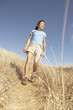 Middle-aged woman walking through tall grass