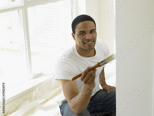 Photo: Young man painting his house Young man painting his house