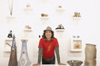 Young man standing by wall of purses