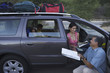 Man examining map by his family minivan