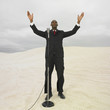 African businessman with microphone in desert