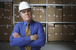 Businessman wearing hard hat in warehouse