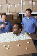 Three male warehouse workers joking around