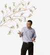 Studio shot of man with money growing on tree