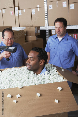 Photo: Three male warehouse workers joking around Three male warehouse workers joking around