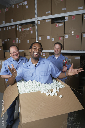 Photo: Three male warehouse workers joking around Three male warehouse workers joking around