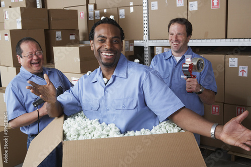 Photo: Three male warehouse workers joking around Three male warehouse workers joking around
