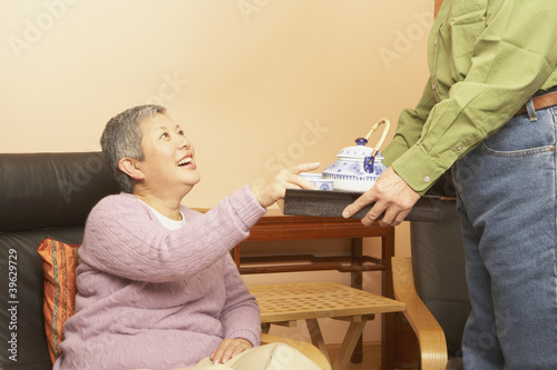 Photo: Senior Asian woman being served tea Senior Asian woman being served tea