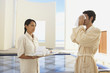 Man in robe using hot towel at hotel