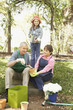 Hispanic grandparents and granddaughter gardening