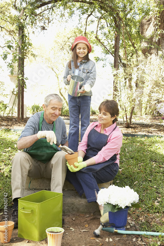 Photo: Hispanic grandparents and granddaughter gardening Hispanic grandparents and granddaughter gardening