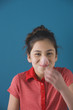 Studio shot of young Hispanic girl with popped bubble gum bubble