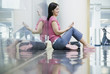 Young woman sitting on reflective floor with mp3 player