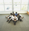 Businesspeople sitting back to back in circle