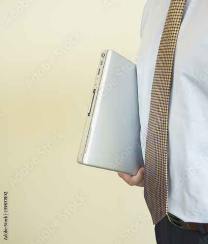 Photo: Close up of laptop under businessman's arm Close up of laptop under businessman's arm