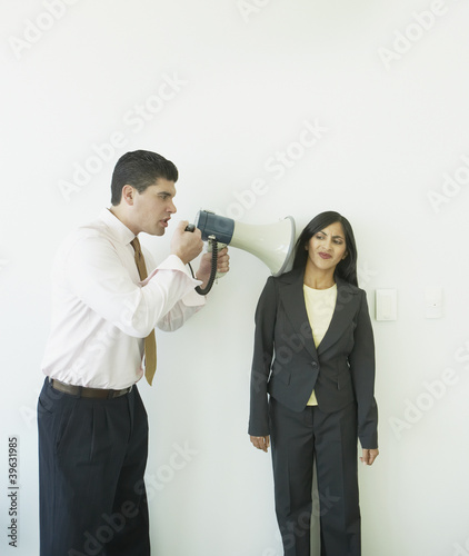 Photo: Businessman with megaphone yelling at businesswoman Businessman with megaphone yelling at businesswoman