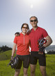 Asian couple wearing bicycle gear in countryside