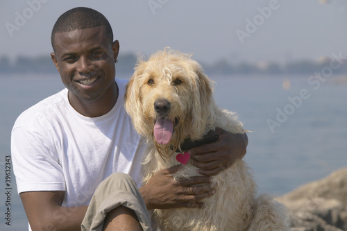 Photo: African man with dog at beach African man with dog at beach