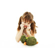A cute little girl looks in disgust at her plate of vegetables
