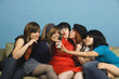 Group of young women taking self-portrait with cell phone on sofa
