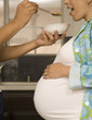 Pregnant woman being fed cereal