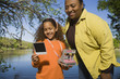African mother and daughter looking at photograph outdoors