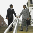 Two businessmen talking on stairs outdoors