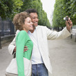 African couple taking own photograph in park