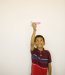 Studio shot of boy playing with toy missile
