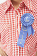 Close up of blue ribbon on man's shirt