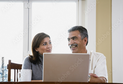Photo: Middle-aged couple using laptop Middle-aged couple using laptop