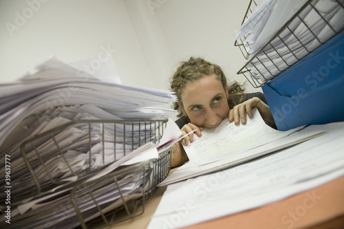 Photo: Hispanic businesswoman biting paperwork Hispanic businesswoman biting paperwork