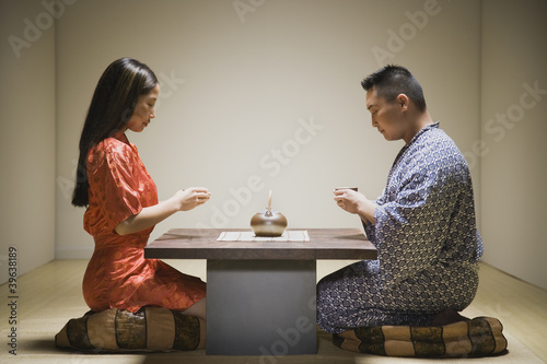 Photo: Asian couple kneeling having tea Asian couple kneeling having tea