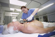Female nurse defibrillating senior male patient