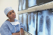 African female doctor looking at x-rays on lightbox