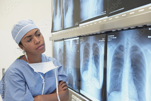 Photo: African female doctor looking at x-rays on lightbox African female doctor looking at x-rays on lightbox