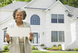African female real estate agent holding contract to house