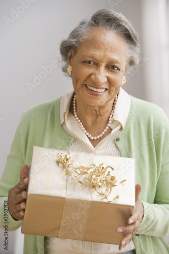 Photo: Senior African woman holding gift Senior African woman holding gift