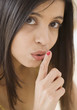 Close up of Hispanic woman with finger up to lips