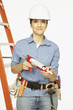 Hispanic female construction worker holding caulking gun