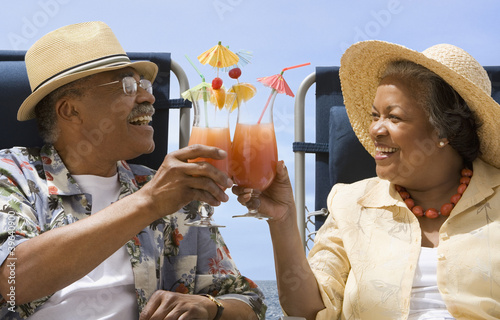 Photo: Senior African couple toasting with tropical cocktails Senior African couple toasting with tropical cocktails
