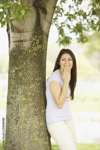 Photo: Portrait of Hispanic woman leaning against tree Portrait of Hispanic woman leaning against tree